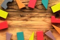 Flat lay of bright colorful wooden figures scattered on wooden light brown planks, abstract background Royalty Free Stock Photo