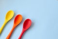 Flat lay of bright multi-colored spoons on a blue background Royalty Free Stock Photo