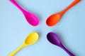 Flat lay of bright multi-colored spoons on a blue background Royalty Free Stock Photo