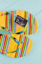 Flat lay bright multicolored flip-flops on a blue background.