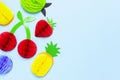 Flat lay bright tropical fruits of paper, strawberry, cherries, pineapple, apple, plum on blue background top view copy