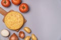 Flat lay of casserole potatoes and tomatoes on a gray background