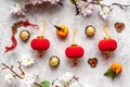 Flat lay of Chinese new year table set with oranges, golden sweets and flowers