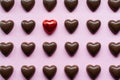 Flat lay with chocolate hearts featuring one candy in a red foil standing out Royalty Free Stock Photo