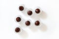 Flat lay with chocolate truffles sprinkled with freeze-dried strawberries in paper wrappers on white background Royalty Free Stock Photo