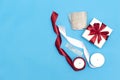 Flat lay with christmas presents, wrapping paper, white and red roll ribbon and crystal isolated on blue background