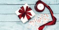 Flat lay with christmas presents, wrapping paper, white and red roll ribbon, heart confetti isolated on blue background