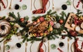 Flat-lay of Christmas table setting with chicken, wine and decorations