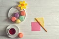 Flat lay. Close up. Bright mood. Colorful french macarons, yellow felt flower, a cup of berry tea, a pencil, stickers. Copy space