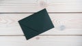 Flat lay of closed sealed green emerald envelope on grey wooden table. Correspondence, mailing, post office, stationary.