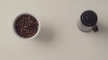 Flat lay of coffee beans, a grinder, and a white ceramic cup on a Royalty Free Stock Photo
