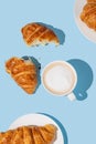 Flat lay of coffee cup and fresh croissants on blue background with shadow Royalty Free Stock Photo