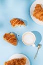 Flat lay of coffee cup and fresh croissants on blue background with shadow Royalty Free Stock Photo