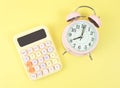 flat lay of colorful calculator and pink alarm clock 8 o clock on yellow background Royalty Free Stock Photo