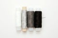 Flat lay colorful cotton thread spools, embroidery white, gray, black, silver, bobbins, mock up, top view. Layout mockup blank