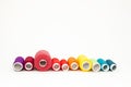 Flat lay with colorful cotton thread spools, embroidery yarn, rainbow bobbins, mock up, top view. Layout mockup on blank white Royalty Free Stock Photo