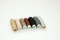 Flat lay colorful cotton thread spools, embroidery yarn, white, brown, gray, black, silver, gold bobbins, mock up, top view. Royalty Free Stock Photo