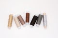 Flat lay colorful cotton thread spools, embroidery yarn, white, brown, gray, black, silver, gold bobbins, mock up, top view.