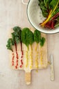 Flat lay of colorful cut stems of Chard vegetables on a wooden chopping board Royalty Free Stock Photo