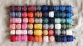 A flat lay of colorful sewing threads and needles arranged on a neutral linen cloth. background Royalty Free Stock Photo