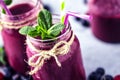 Flat-lay of colorful smoothies in bottles with tropical fruit and superfoods on concrete background Royalty Free Stock Photo