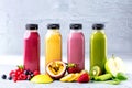 Flat-lay of colorful smoothies in bottles with tropical fruit and superfoods on concrete background Royalty Free Stock Photo