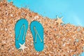 Flat lay of composed miniature of beach lounge area, small sea stars, summer flip-flops