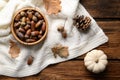 Flat lay composition with acorns, pumpkin and white knitted fabric on wooden table Royalty Free Stock Photo