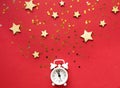 Flat lay composition. Alarm clock and Christmas decorations on red background. top view, copy space