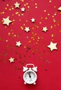 Flat lay composition. Alarm clock and Christmas decorations on red background. top view, copy space