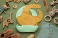 Flat lay composition with baby accessories and bibs on green background