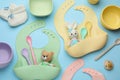 Flat lay composition with baby accessories and bibs on light blue background