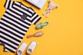 Flat lay composition with baby clothes and accessories on yellow background. Space for text Royalty Free Stock Photo