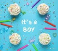 Flat lay composition with baby shower cupcakes for boy on blue background Royalty Free Stock Photo