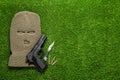 Flat lay composition with balaclava and weapons on grass. Space for text Royalty Free Stock Photo