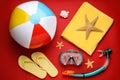 Flat lay composition with ball and beach objects on red background Royalty Free Stock Photo