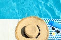 Flat lay composition with beach accessories on wooden deck near swimming pool. Royalty Free Stock Photo