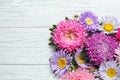 Flat lay composition with beautiful aster flowers on wooden table. Space for text Royalty Free Stock Photo