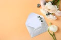 Flat lay composition with beautiful ranunculus flowers and card in envelope Royalty Free Stock Photo