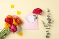 Flat lay composition with beautiful ranunculus flowers and card in envelope on color background Royalty Free Stock Photo
