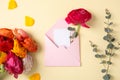 Flat lay composition with beautiful ranunculus flowers and card in envelope on color background Royalty Free Stock Photo