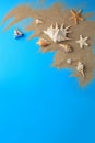 Flat lay composition with beautiful starfishes and sand on blue background. Space for text Royalty Free Stock Photo