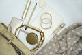 Flat lay composition of beauty products and handbag for women. Pastel and gold colors on white background.