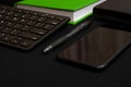 Flat lay composition with black pen, computer keyboard, smartphone, smart watch, leather wallet and bright green notebook on dark Royalty Free Stock Photo