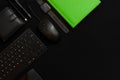 Flat lay composition with black pen, computer keyboard, smartphone, smart watch, leather wallet and bright green notebook on dark Royalty Free Stock Photo