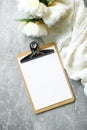 Flat lay composition with blank paper clipboard mockup, peony flowers and beige cloth on stone background. Top view wedding Royalty Free Stock Photo