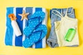 Flat lay composition with blue Beach accessories on yellow color background. Summer holiday background. Vacation and travel items Royalty Free Stock Photo
