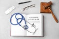 Flat lay composition with book, gavel, pills Royalty Free Stock Photo