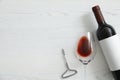 Flat lay composition with bottle of wine and elegant glass on white wooden background Royalty Free Stock Photo