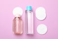 Flat lay composition with bottles of micellar water and cotton pads on background